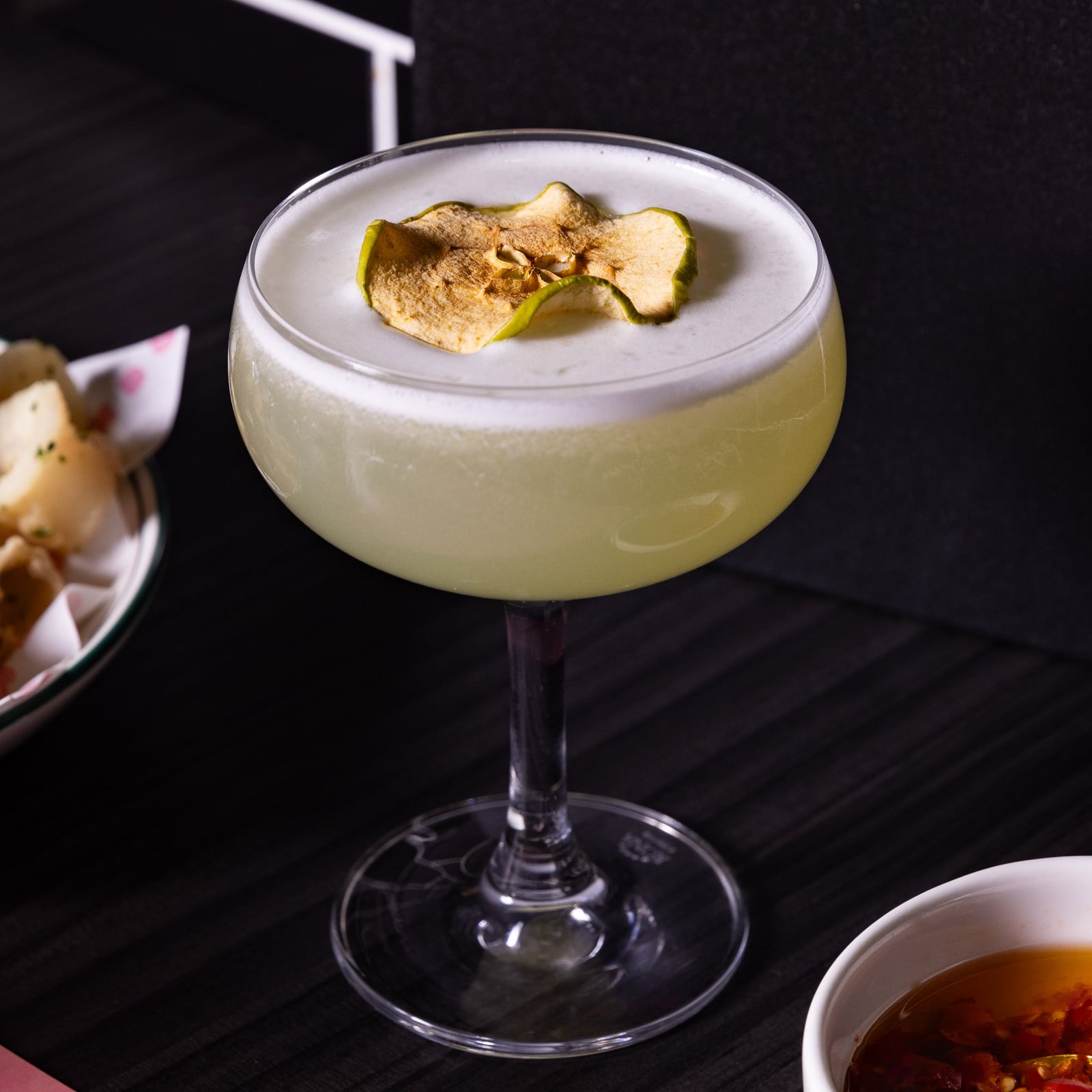 Apple garnish cocktail on dark table