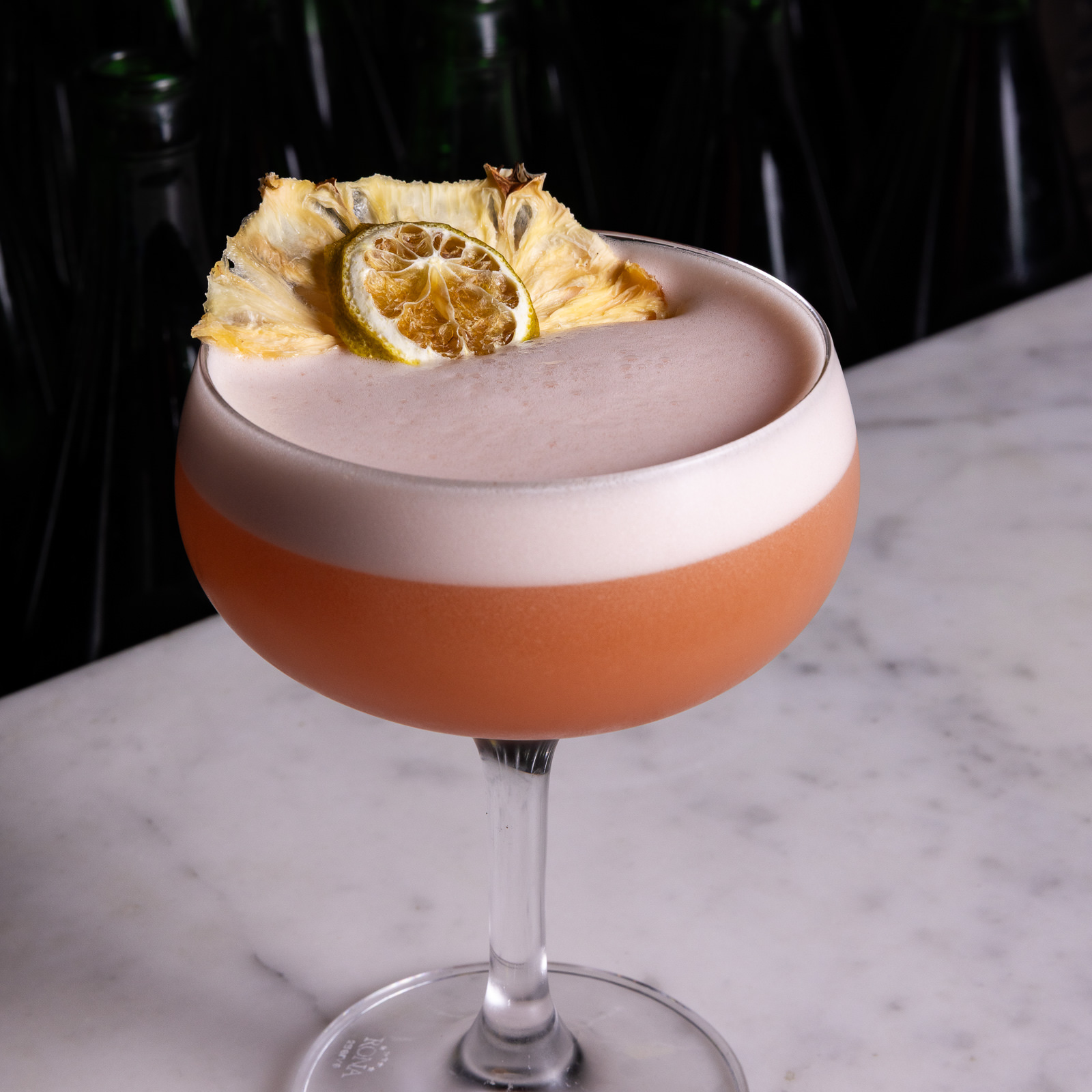 Fruity cocktail with pineapple and citrus garnish.